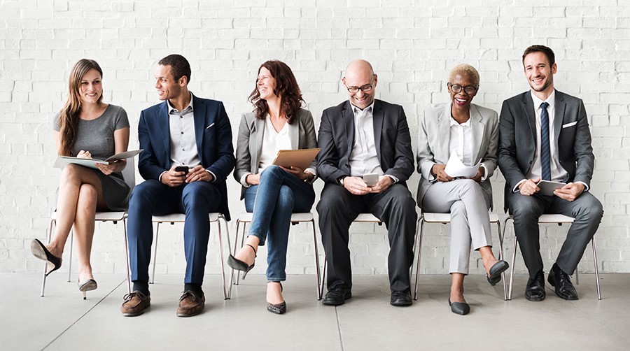 Happy adults dressed in business formal attire sitting in a waiting room